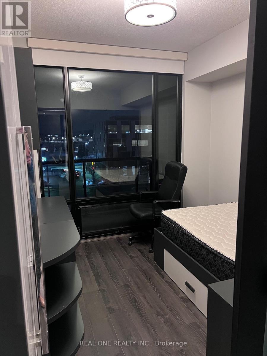 A bedroom with a bed, desk, and chair.