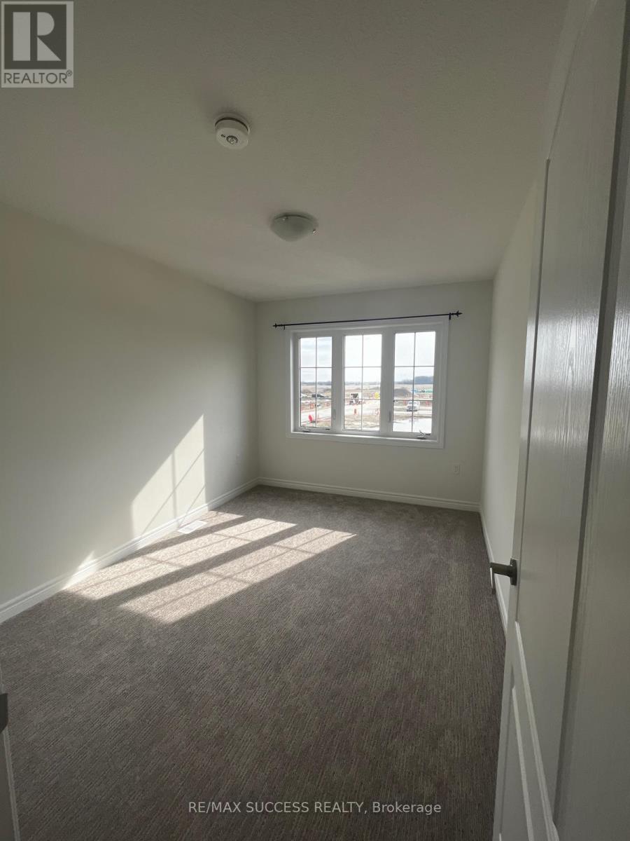 A room with a window and a carpeted floor.