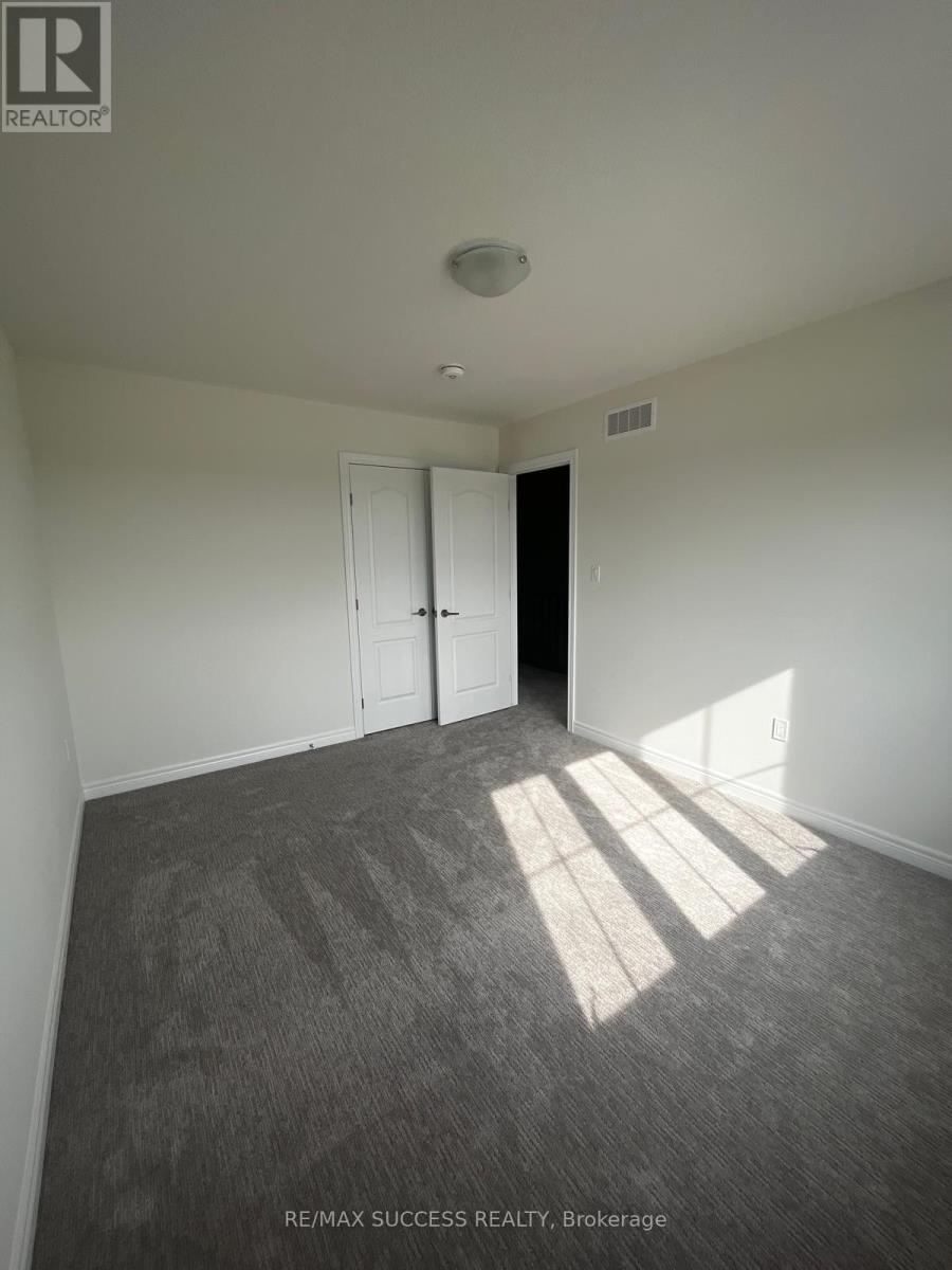 A room with a carpeted floor and a door on the right side.