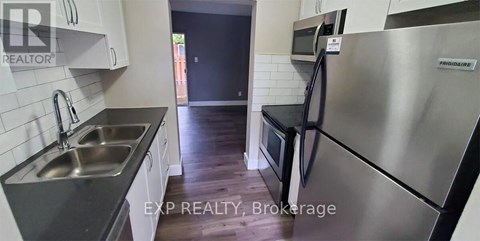 A kitchen with a stainless steel refrigerator and a sink.