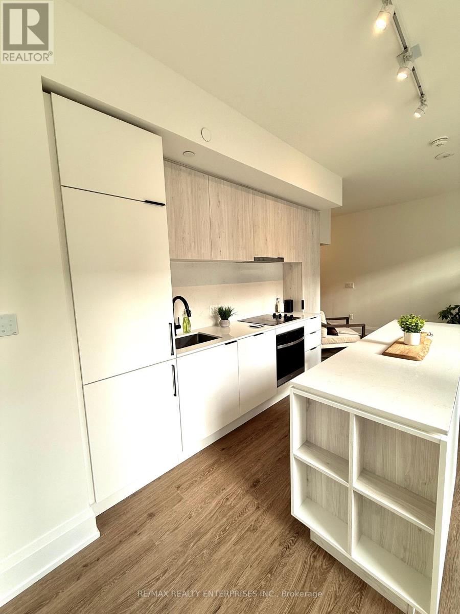 A kitchen with white cabinets and a wooden floor.