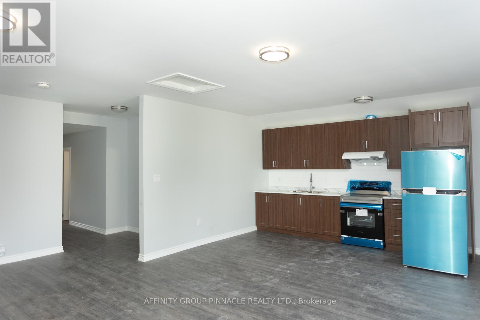 A kitchen area with a blue fridge and a stove top oven.