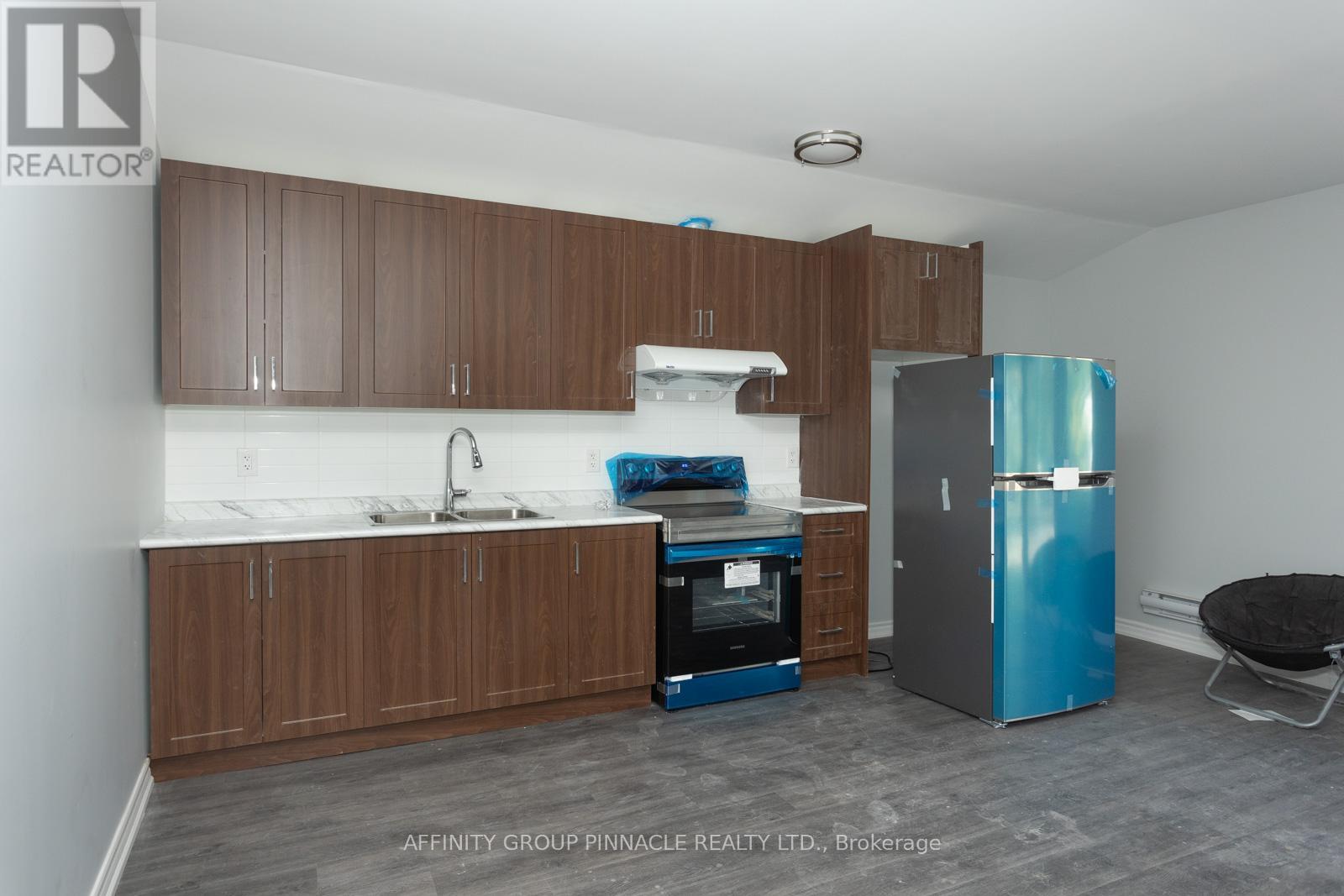 A kitchen with brown cabinets and a blue fridge.