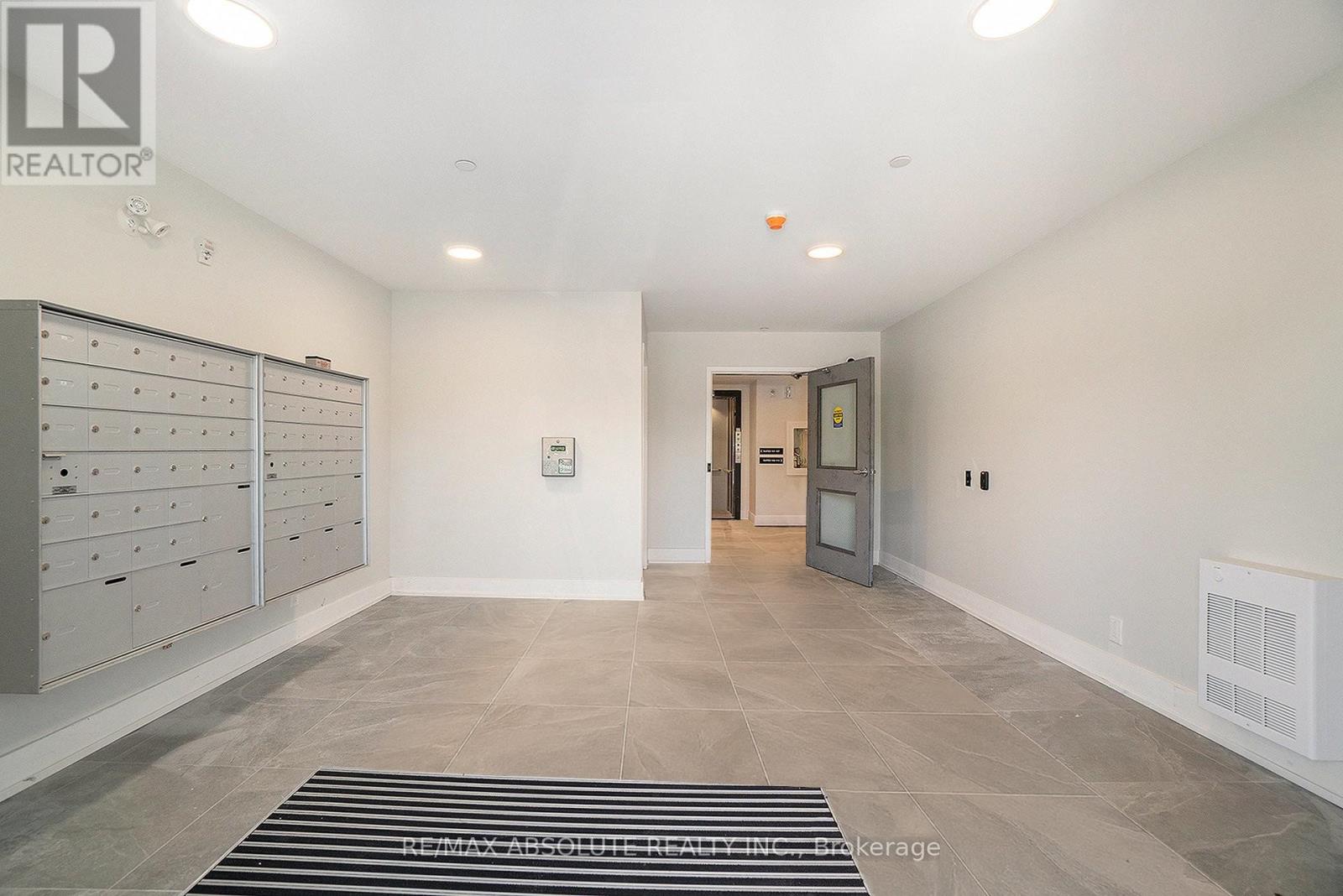 A room with a row of filing cabinets on the left and a doorway in the middle of the room.