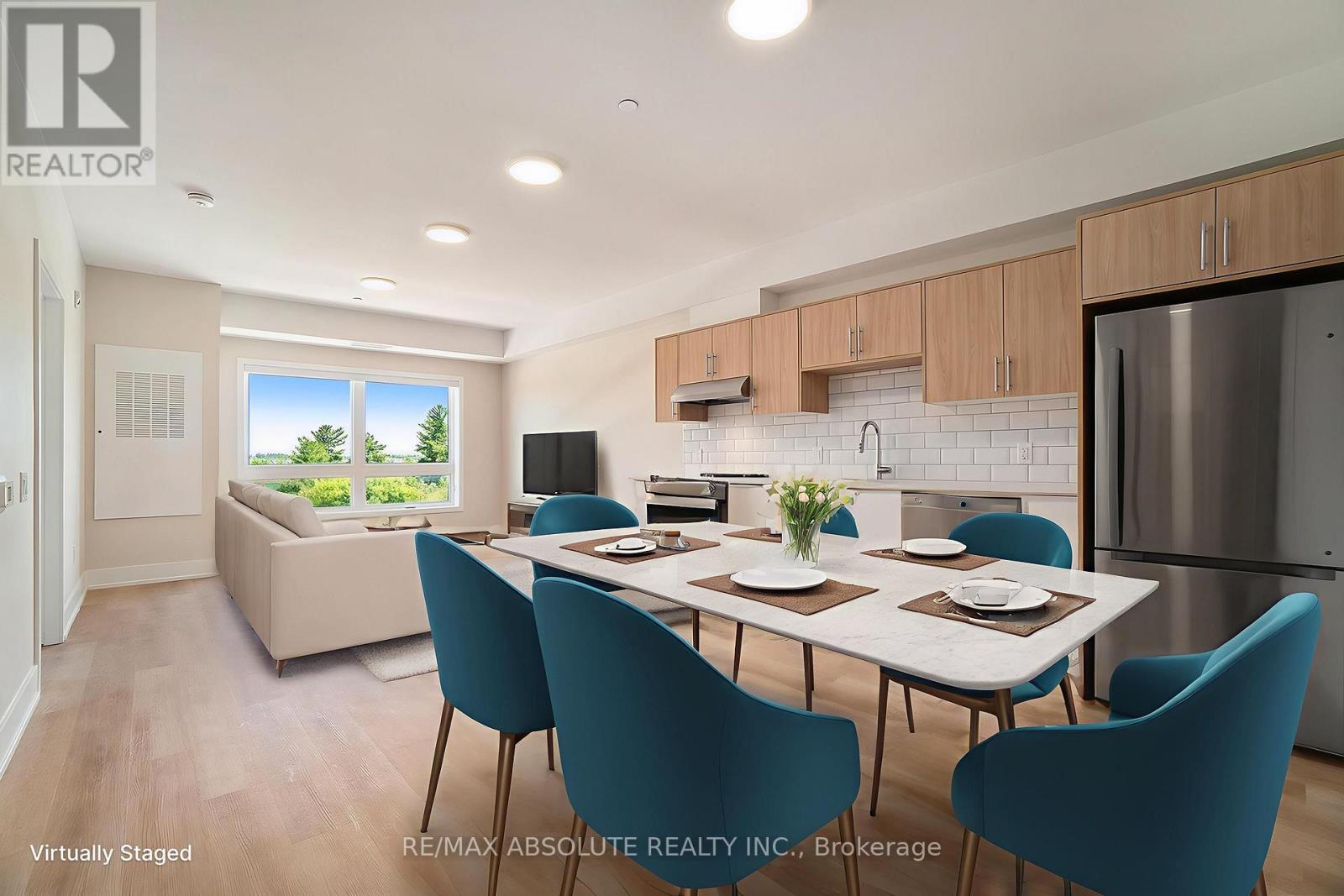A dining room with a table set for four and a kitchen area in the background.