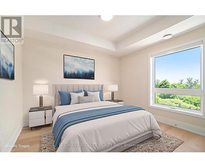 A bedroom with a large bed and a window overlooking a green landscape.