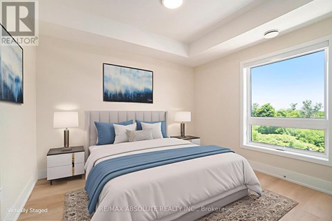 A bedroom with a large bed and a window overlooking a green landscape.