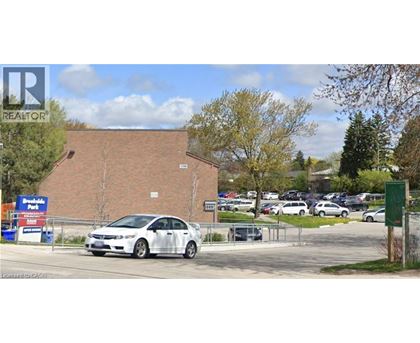 A white car is parked in front of a building with a sign that says "REALTOR".