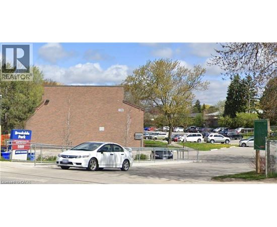 A white car is parked in front of a building with a sign that says "REALTOR".