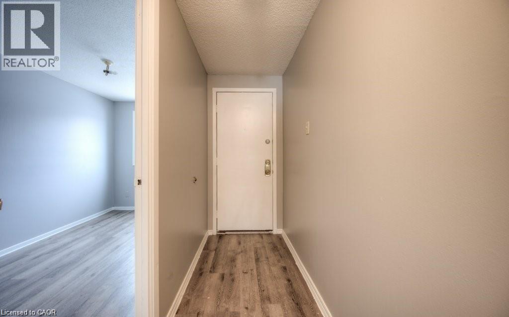 A hallway with a white door and wooden floor.