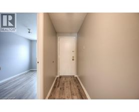 A hallway with a white door and wooden floor.