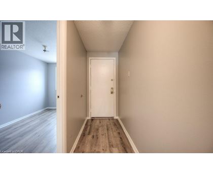A hallway with a white door and wooden floor.