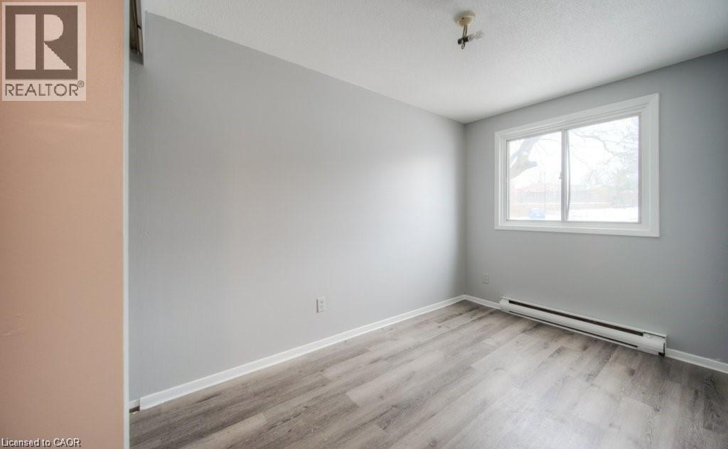 A room with a window and a wooden floor.