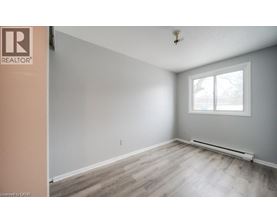 A room with a window and a wooden floor.