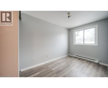 A room with a window and a wooden floor.