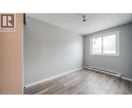 A room with a window and a wooden floor.