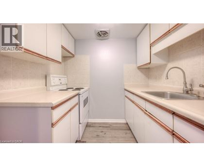 A small, white kitchen with a sink and a refrigerator.
