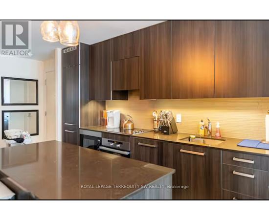 A modern kitchen with dark wood cabinets and a central island.