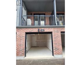 A garage door is open to reveal a clean, empty garage inside.