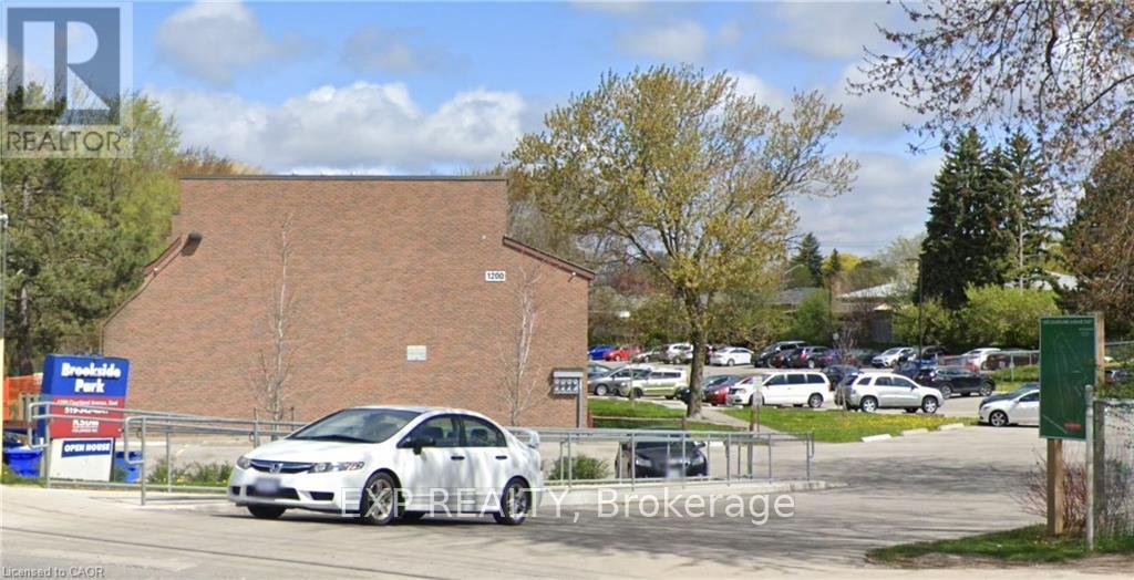 A car is parked in front of a REALTY Brokerage sign.