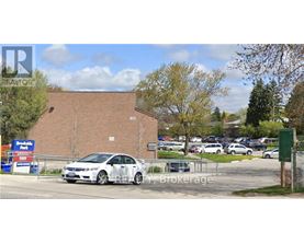 A car is parked in front of a REALTY Brokerage sign.