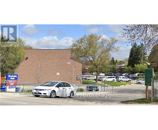 A car is parked in front of a REALTY Brokerage sign.