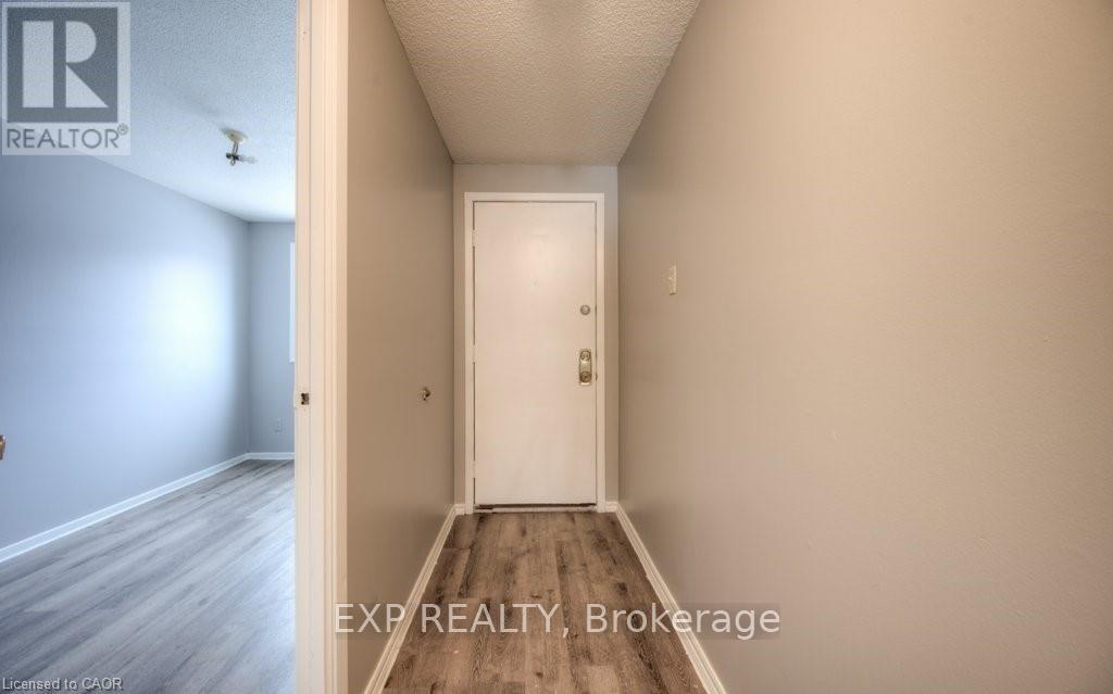 A hallway with a white door and a light switch on the wall.