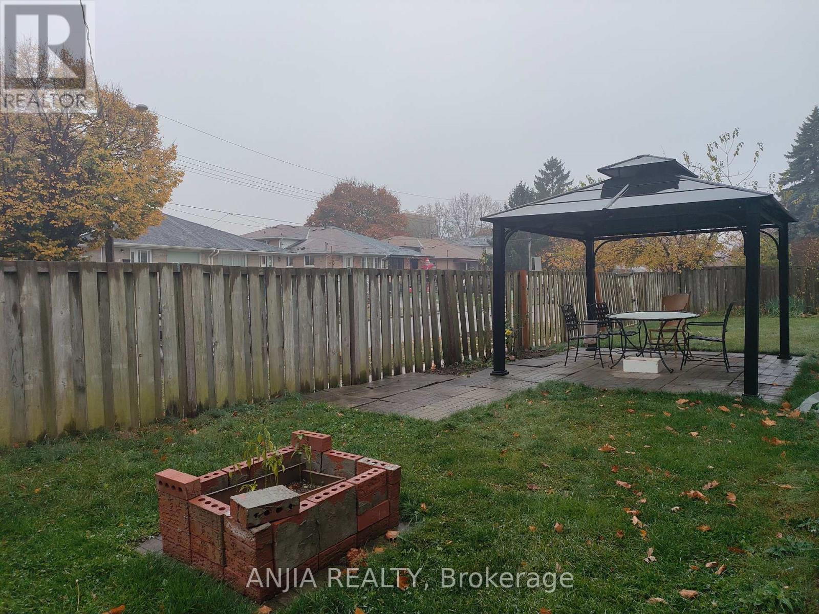 A backyard with a gazebo and a fire pit.