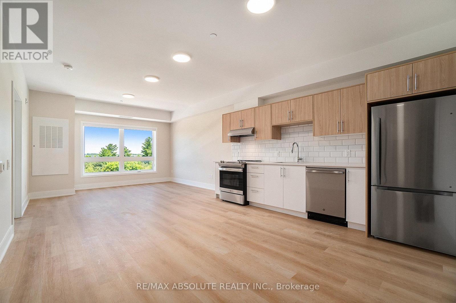 A kitchen with wooden floors and stainless steel appliances.