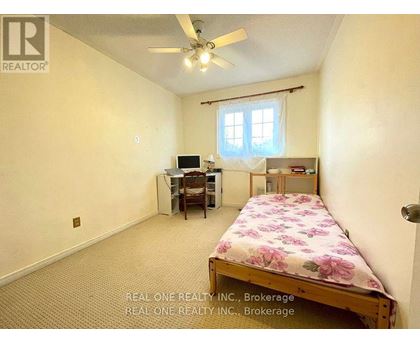 A bedroom with a bed, desk, and chair.