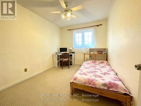 A bedroom with a bed, desk, and chair.