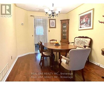 A dining room with a wooden table and chairs.