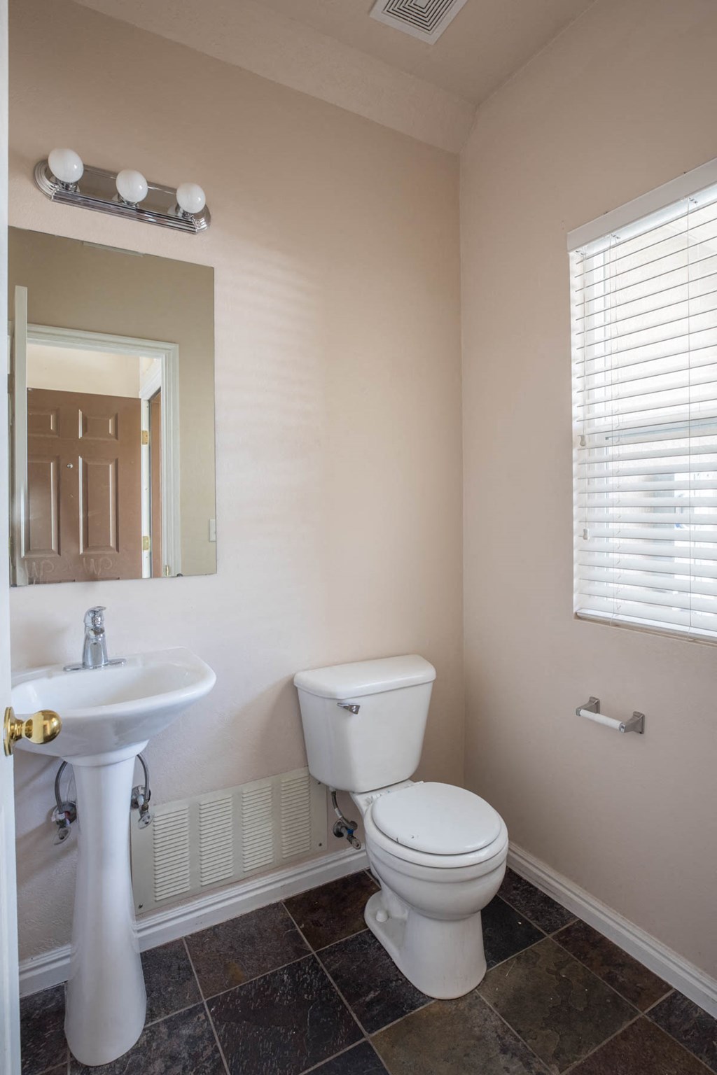 a bathroom with a toilet and a sink and a mirror