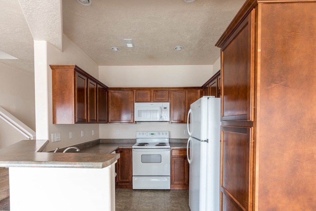 a kitchen with white appliances and wooden cabinets