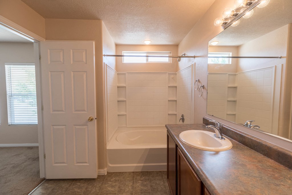 a bathroom with a shower and a sink and a mirror