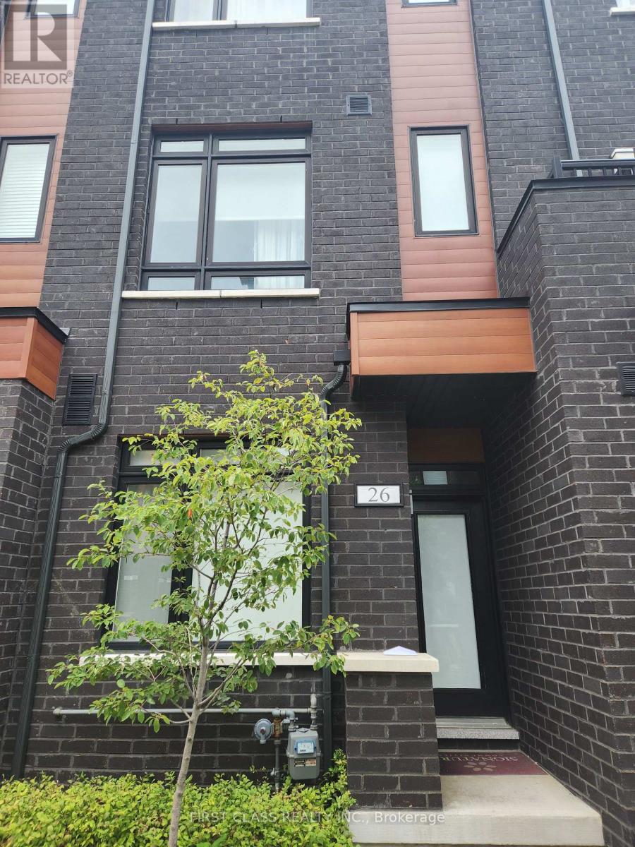 A tree in front of a brick building with a door and windows.