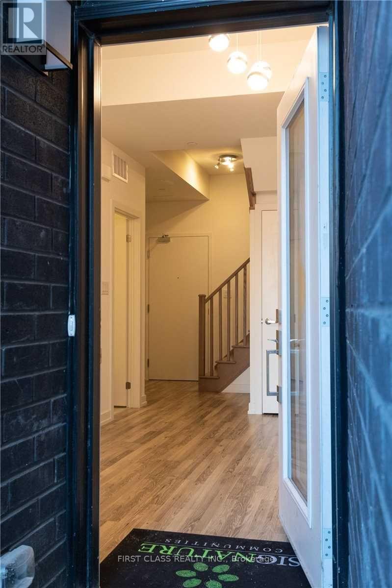A hallway with a staircase and a doorway leading to another room.