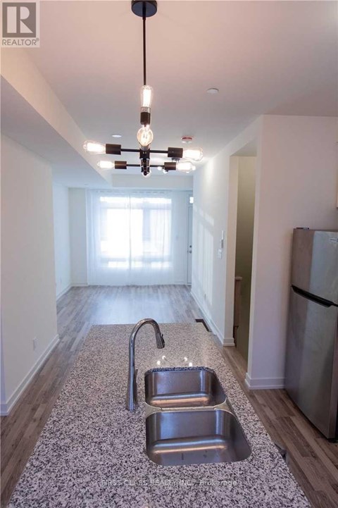 A kitchen with a sink and a fridge.
