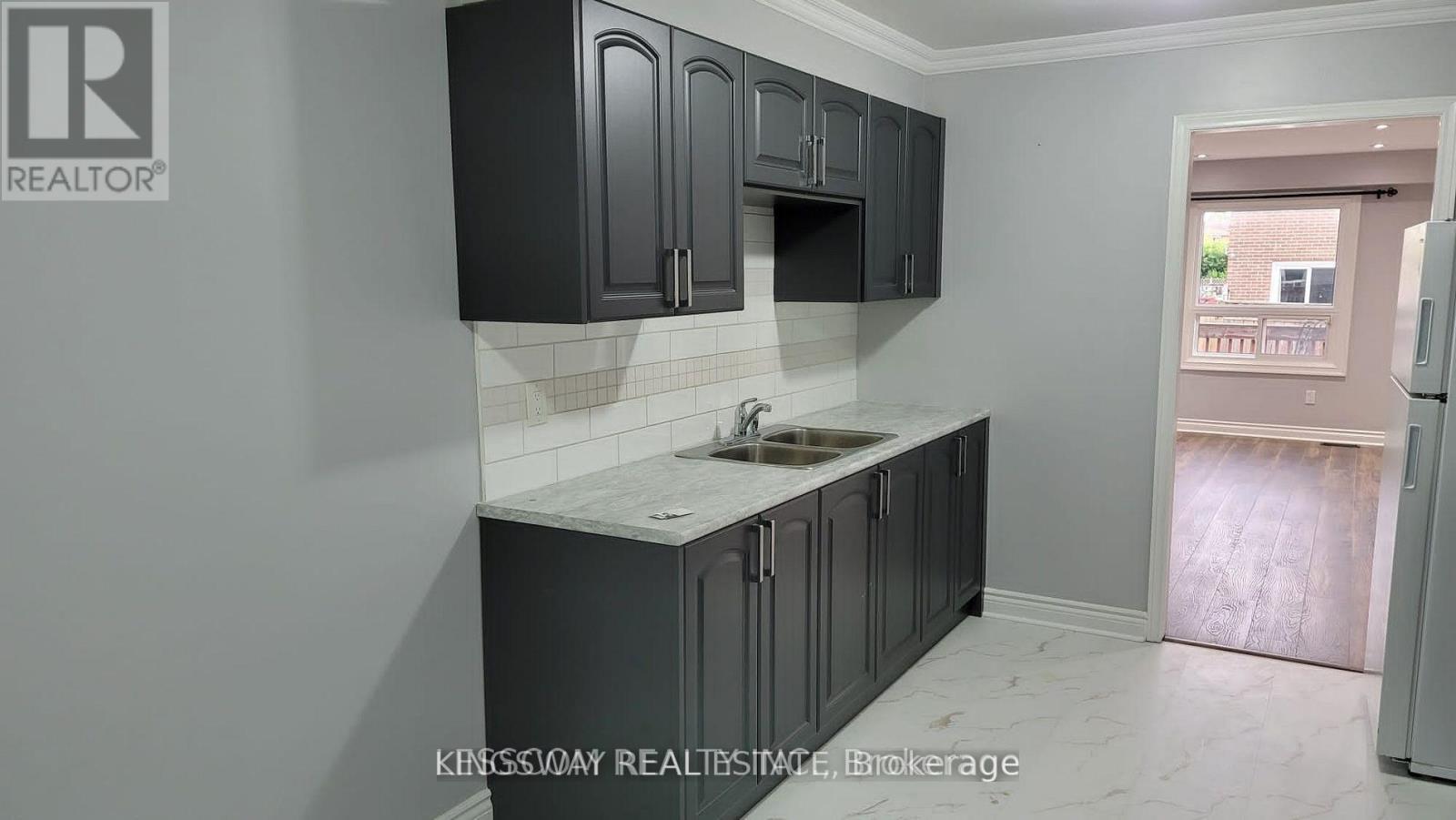 A kitchen with black cabinets and a white countertop.