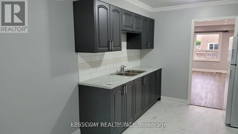 A kitchen with black cabinets and a white countertop.