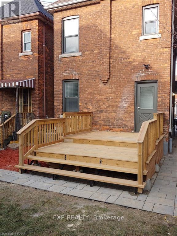 A wooden deck in front of a brick building.