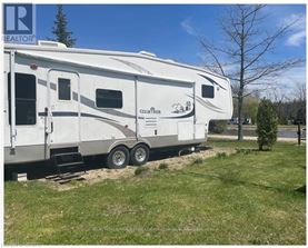 A white RV is parked in a grassy area.