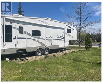 A white RV is parked in a grassy area.