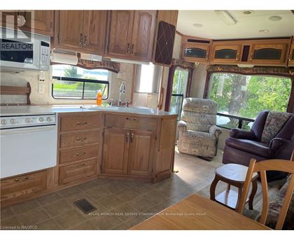 A kitchen area with wooden cabinets and a white stove.