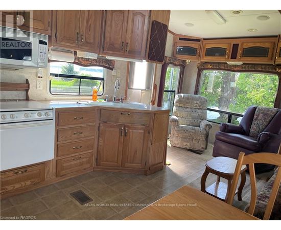 A kitchen area with wooden cabinets and a white stove.