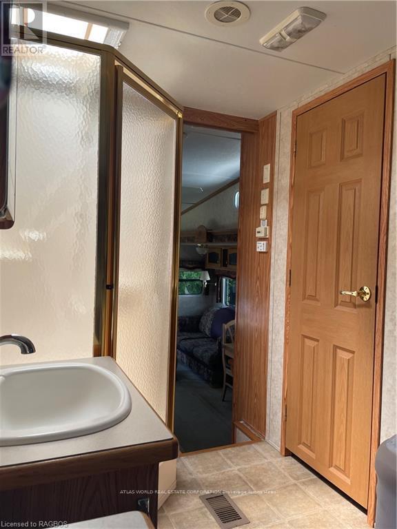 A bathroom with a sink, mirror, and wooden door.
