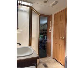 A bathroom with a sink, mirror, and wooden door.