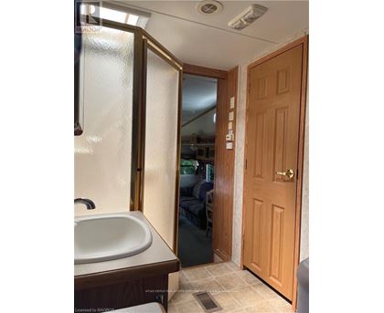 A bathroom with a sink, mirror, and wooden door.