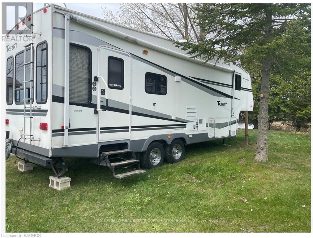 A white RV is parked in a grassy area.