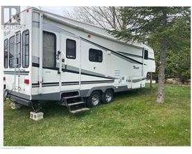 A white RV is parked in a grassy area.